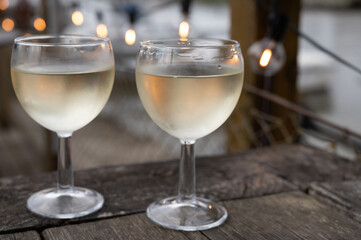 Tasting of Bordeaux white wine, right bank of Gironde Estuary, France. Glasses of white sweet French wine served in outdoor restaurant on oysters farm in Gujan-Mestras, Arcachon bay