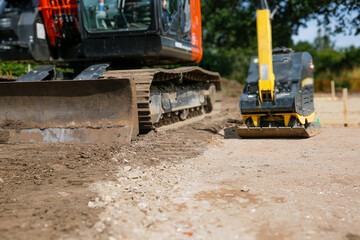 A large orange excavator standing on ground of construction site. Building a family house