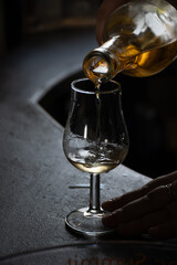 Tasting of cognac spirit aged in old dark French oak barrels in cellar distillery house, Cognac...