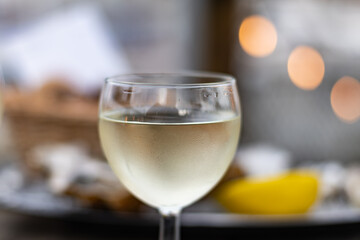 Tasting of Bordeaux white wine, right bank of Gironde Estuary, France. Glasses of white sweet French wine served in outdoor restaurant