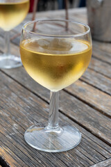 Tasting of Bordeaux white wine in Sauternes, left bank of Gironde Estuary, France. Glasses of white sweet French wine served in outdoor restaurant