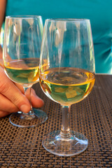 Tasting of Bordeaux white wine in Sauternes, left bank of Gironde Estuary, France. Glasses of white sweet French wine served in restaurant