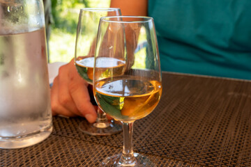 Tasting of Bordeaux white wine in Sauternes, left bank of Gironde Estuary, France. Glasses of white sweet French wine served in restaurant