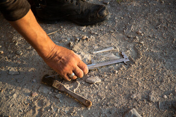 An archaeologist measures a found artifact in the form of bones. Historical reconstruction of...