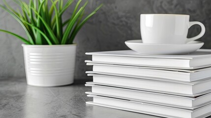 A white mug sits atop a stack of magazines against a blurred background of lush green foliage