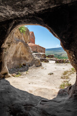 Uplistsikhe cave town in Georgia. Mountainous landscape of Uplistsikhe. Ancient Orthodox Church in antique cave city Uplistsikhe. UNESCO site.