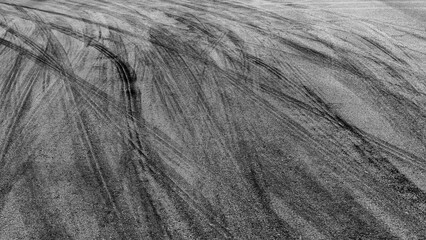 Aerial view Textured background vehicle trace on asphalt road, Tire print texture background transport, Car tire mark burnout texture and background, Tire mark on the asphalt road race track.