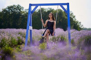Young woman in a swing in a lavender field