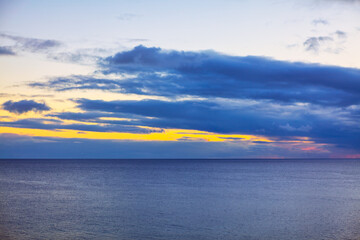 Ocean is calm and the horizon is visible in the twilight