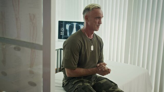 Handheld shot of devastated Caucasian middle-aged soldier having panic attach while visiting clinic