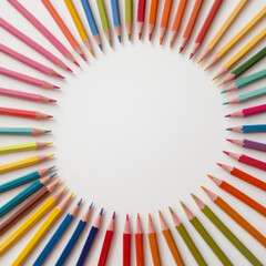 A flat lay of colored pencils arranged in a circular pattern, with a clean white backdrop.