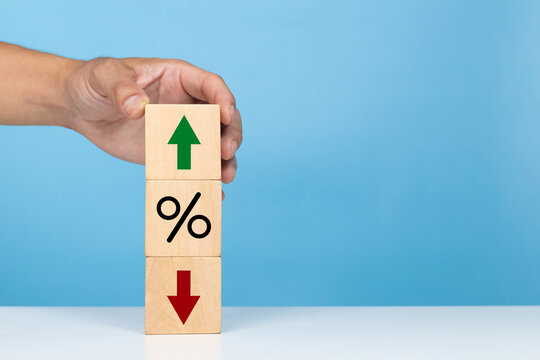 Financial, stocks, interest rate and GDP percent change. Hand show wooden block with percentage sign and arrow up sign and down for interest rate ,ranking ,financial stocks and GDP percent