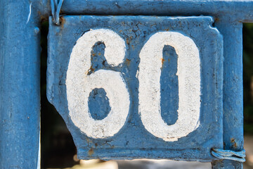 Old retro weathered cast iron plate with number 60