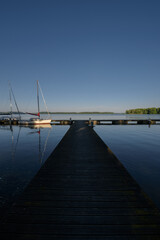 LANDSCAPE BY THE LAKE - Sailboats moored to a pier on the lake shore