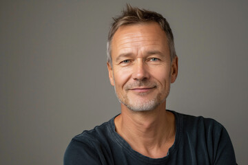 Obraz premium Cheerful Mid-aged Man Smiling at Camera in Casual Attire