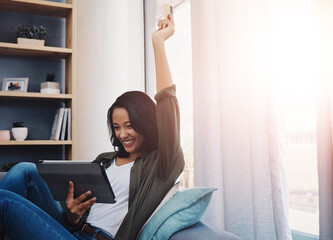 Woman, celebrating and excited with tablet on sofa, streaming and happy for movie or series plot...