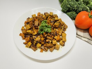 Oseng Tempe and Tofu is Indonesian stir-fried tempeh, tofu and carrot seasoned with shallots, garlic, salt, bay leaf, galangal and sweet soy sauce served on white plate