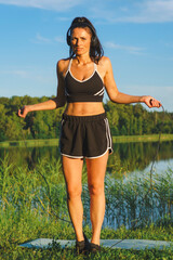 Beautiful woman exercising in the wild near the lake