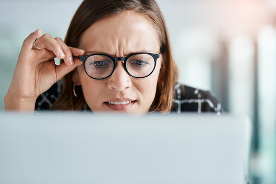 Girl, online and confused in office for reading miscommunication, unclear instructions and new software. Woman, glasses and closeup with laptop or uncertain for information overload and research.