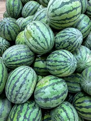 Obraz premium Fresh organic watermelons close-up, top view. There are a lot of whole watermelons in the market window. 
