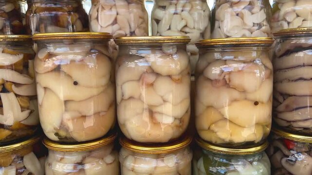 There are a lot of different canned mushrooms in jars. Homemade mushroom pickles. Harvesting mushrooms for the winter. Mushroom delicacies for the table.
