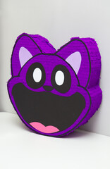 purple cat piñata made of cardboard, piñata with candies for a children's party