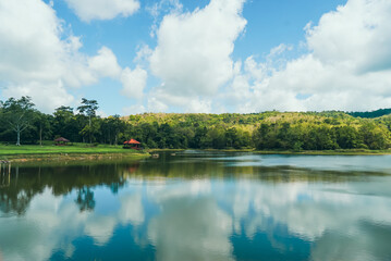 Fototapeta premium Lake with clear blue sky and white clouds, beautiful endless green mountains and waters at Jedkod Pongkonsao Natural Study in Saraburi, Thailand