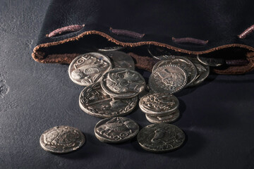 Leather pouch full of ancient silver coins © allexxandarx
