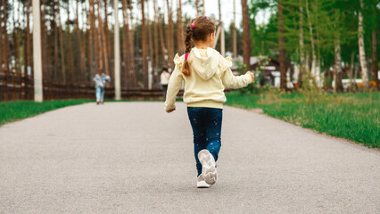 Childhood. Child run on path in spring or summer park. Childhood activity, leisure, lifestyle. Energy, growth, youth concept.