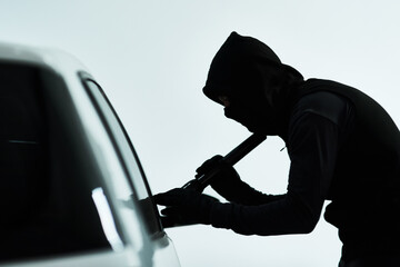 Man, car and steal attempt with criminal, automobile and flash light or checking for valuable possession inside. Illicit, assessing vehicle and security for anti theft system, hooded and parking lot