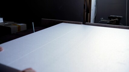 A white sheet of foam plastic is cut with a hot wire. Polystyrene foam is cut using a hot wire....