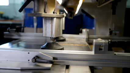 Industrial processing and cutting of wooden boards by carpenters and machine tools. Woodworking equipment, cutting close-up. Equipment from a furniture factory in operation.