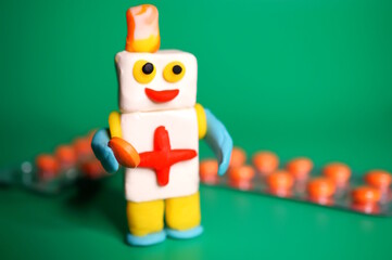 A toy robot medic with a pill in his hand. Robotics in medicine.