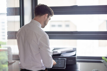 Fototapeta premium Businessman Using Photocopier