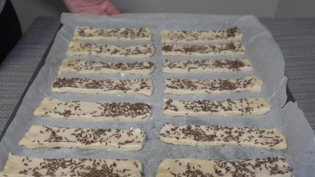 pastry dough on a baking sheet, The dough is sprinkled with cumin on a baking sheet