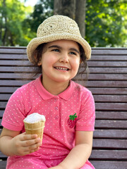 Portrait of a happy brunette girl with ice cream in her hand on a walk in the park. 