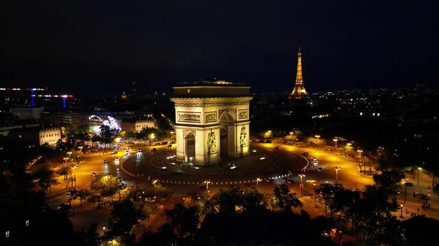 Paris, Arc de Triomphe Triumphal Arch at Chaps Elysees at night, Paris, France. Drone view, Eiffel Tower in the background.  Architecture and landmarks of Paris. Postcard of Paris
