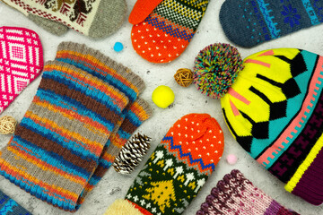 Knitted warm clothes in the form of a hat, mittens, scarf. Clothes for autumn and winter. Scarf, hat and mittens seen from above.