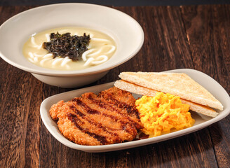 Gillette Pork Chop Udon Soup with Tender Scrambled Eggs and sandwich served in dish isolated on background side view of hong kong fasfood