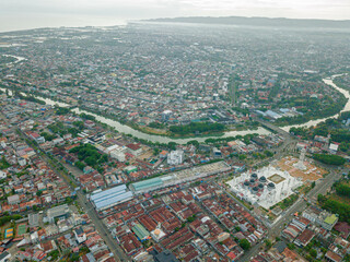 Aerial drone view of big city scenery with Masjid Raya Baiturrahman in Banda Aceh, Aceh, Indonesia.