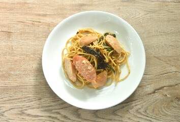 spicy stir fried spaghetti slice pork sausage with dry chili and basil leaf on plate