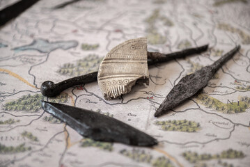 Part of a bone comb (comb) from the 1st-3rd century AD with patterns. Vulture culture. against the background of other old iron things.