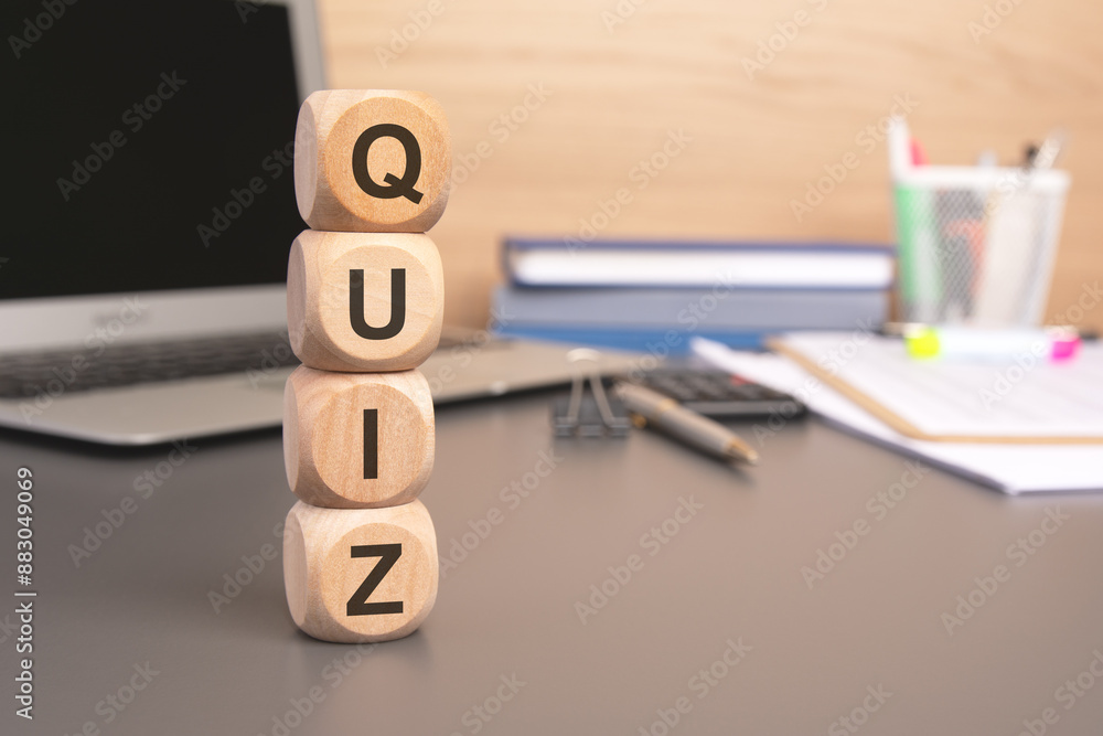 Aufkleber the word quiz written on wooden cubes against computer keyboard background