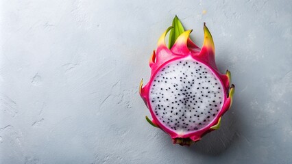 Pink dragon fruit cut in half with green leaves on a blue background