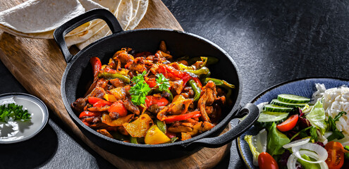 Fajita with peppers and onions served on a hot iron skillet