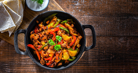 Fajita with peppers and onions served on a hot iron skillet