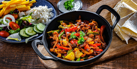 Fajita with peppers and onions served on a hot iron skillet