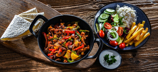 Fajita with peppers and onions served on a hot iron skillet