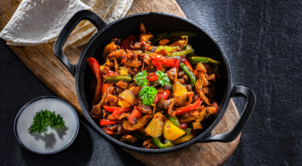 Fajita with peppers and onions served on a hot iron skillet