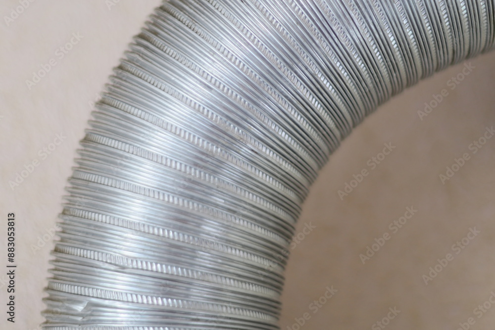 Poster a detailed view of a metal pipe attached to a wall, suitable for use in industrial or construction c
